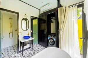 une salle de bain avec une machine à laver et un lave-linge dans l'établissement Rosie Countryside villa- 1BR retreat, à Hiếu Nhơn
