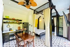 - une cuisine avec une table et un lit dans une chambre dans l'établissement Rosie Countryside villa- 1BR retreat, à Hiếu Nhơn