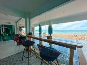 a room with a bar with chairs and a view of the ocean at Baan Sailboat Beach Kohlarn in Ko Larn