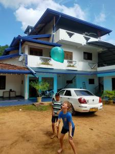 two children standing in front of a house with a blue balloon at Mayka's luxury holiday homes and Safari Thanamalwila in Tanamalwila