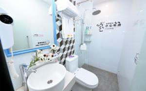 笑脸里青年旅舍锦里店 في تشنغدو: حمام به مرحاض أبيض ومغسلة