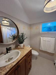 a bathroom with a sink and a toilet and a mirror at Villa Metro country Club in Juan Dolio