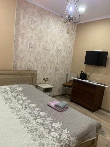 a bedroom with a bed and a dresser and a television at Beautiful Tbilisi on Meskhishvili Turn in Tbilisi City