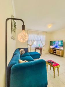 a living room with a blue couch and a tv at RetroRhapsody in Gold Coast