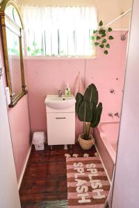 a pink bathroom with a sink and a potted plant at RetroRhapsody in Gold Coast