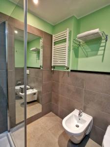 a bathroom with a sink and a toilet and a mirror at Mansio Residence & Hotel in Elmas
