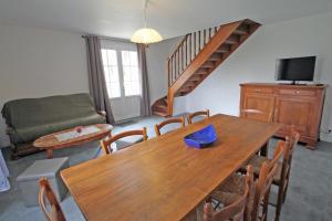 a living room with a wooden table and a couch at Le monteil in Saint-Sornin-Leulac