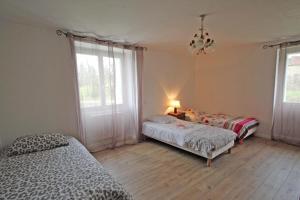 a bedroom with two beds and a lamp and a window at Le monteil in Saint-Sornin-Leulac