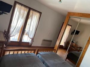 a bedroom with two beds and a mirror in it at La maison d'hôtes des ferrages in Tavernes