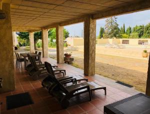 a porch with chairs and a table and a view at La maison d'hôtes des ferrages in Tavernes