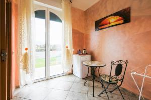 a small table and chair in a room with a window at Villamir B&B in Albenga