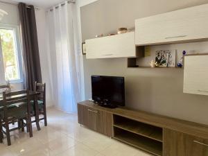 a living room with a flat screen tv on a cabinet at Appartamento Valamar Nikolla 2 camere in Hamallë