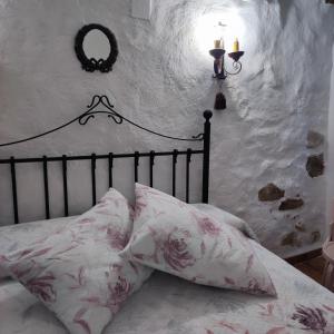 a bedroom with a bed with pink and white pillows at La casa del Herrero in Villanueva de Viver +14 photos