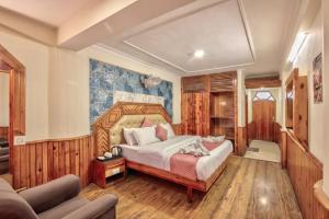 una camera da letto con un letto e un divano di Hotel Ibex a Manāli