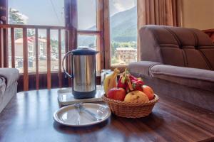 un cesto di frutta su un tavolo con uno spremiagrumi di Hotel Ibex a Manāli
