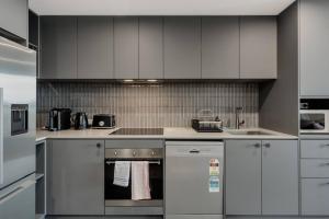 ベルコナンにあるBeautiful 2 BR Lakeside Viewの白いキャビネットとコンロ付きオーブンを備えたキッチン