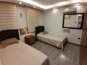 a hotel room with two beds and a mirror at SAKN 3 - Two Bedroom Apartment in Amman