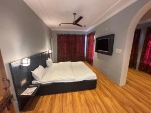 a bedroom with a bed and a flat screen tv at Silk Route in Srinagar