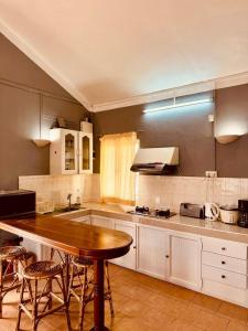a kitchen with a wooden table and some chairs at Baleau Villa in Pereybere