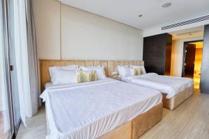 una camera da letto con due letti con lenzuola bianche di FIRST CLASS 1BR Anantara The Palm Hotel a Dubai Altre 25 foto