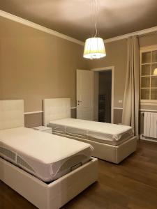 a bedroom with two beds and a chandelier at Villa il Giglio in Marina di Mancaversa +42 photos