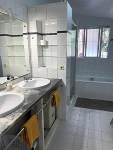 a white bathroom with two sinks and a shower at Elviria Beachside House Marbella in Marbella +14 photos