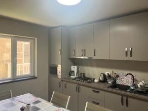 a kitchen with white cabinets and a table and a window at Marald Eforie Nord in Eforie Nord