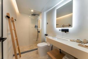 a bathroom with a sink and a toilet and a mirror at Miss Autumn House in Yangshuo +31 photos