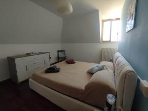 a bedroom with a bed with a couch and a window at il Rifugio di Franco e Silvia in San Benedetto del Tronto