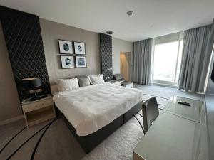 リヤドにあるبرج داماك الرياض DAMAC Towers Riyadhの大きなベッドと窓のあるホテルの部屋