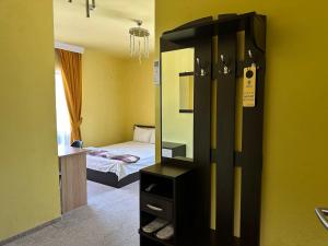 a small bedroom with a bed and a mirror at Complex MONACO HOTEL & CASINO in Svilengrad