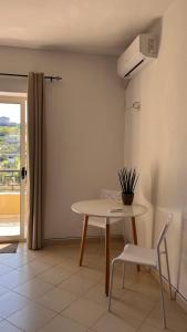 a table and a chair in a room with a window at Kate Apartment in Durrës