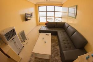 - un salon avec un canapé et une table dans l'établissement Newcenter Suites, à Tanger