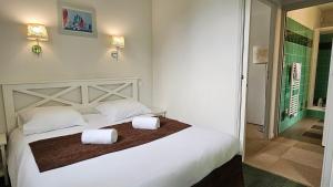 a bedroom with a large bed with two towels on it at Maya - Piscine - Calme - Parking in Baden