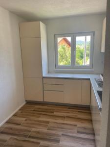 an empty kitchen with a window on the wall at Vidovdanska house in Šipovo +13 photos