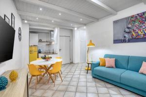 a living room with a blue couch and a table at Appartamento Terza Strada "3rd Avenue-HolidayHome" in Civitavecchia