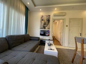 a living room with a couch and a tv at kestel city 1 in Alanya