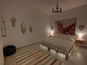 a bedroom with a bed with a painting on the wall at Cozy Apt in amman with a view in Amman