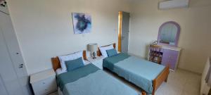 a bedroom with two beds and a dresser and a mirror at Villa Konstantinos with Private Pool in Paphos +24 photos