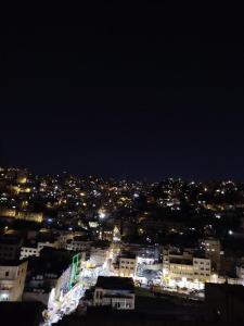 a view of a city at night with lights at Cozy Apt in amman with a view in Amman