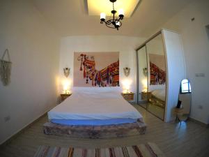 a bedroom with a large bed and a mirror at Cozy Apt in amman with a view in Amman