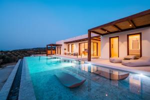 a villa with a swimming pool at night at Noema Luxury Retreat Villas - Adults only in Kos Town