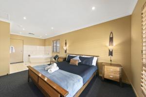 um quarto com uma cama grande e uma banheira em Broken View Estate em Pokolbin