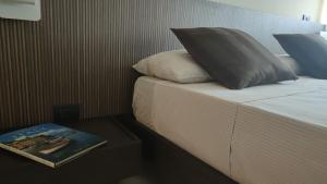 a bed with a pillow and a book on it at Apartments Velasca in Milan