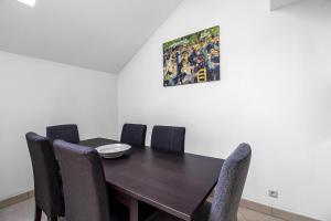 a dining room table with chairs and a painting on the wall at Sweet-Gerson, calme, proche gare, parking privé in Roeser +11 photos