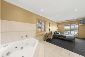 um banheiro grande com banheira e cama em Broken View Estate em Pokolbin