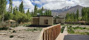 a house in the middle of a field with mountains at Devaranya Homestay in Leh