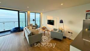 a living room with a view of the ocean at Sail Penthouse - Beach & Parking in Kent