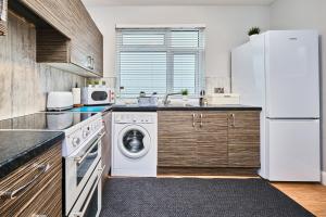 a kitchen with a white refrigerator and a dishwasher at Princess Yellow 1 - Portrush by the Sea in Portrush