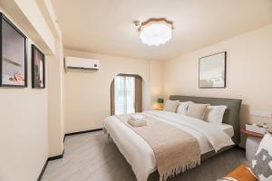 Postel nebo postele na pokoji v ubytování Guangzhou He She Art Apartment
